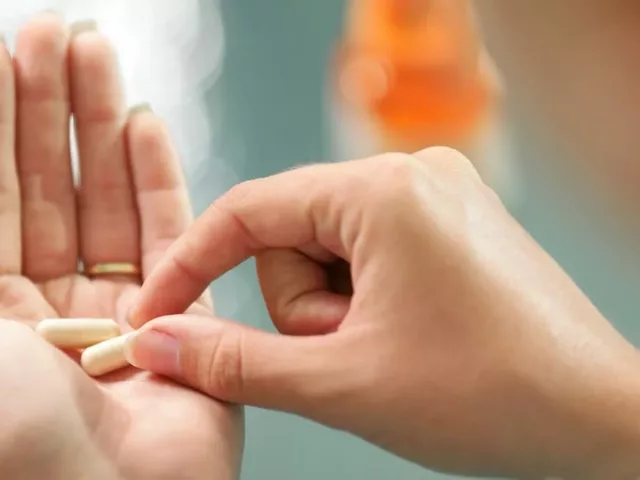 Woman holding the best probiotic capsule in her palm
