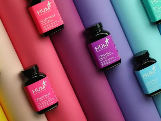 HUM Nutrition supplement bottles on rainbow spectrum