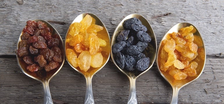 Four spoonfuls of dried fruit on wooden table