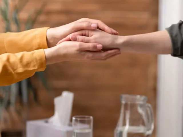 Therapist holding client's hand during a successful talk therapy session