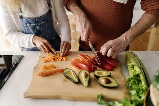 Couple chopping food to store fresh in fridge