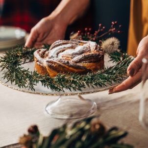 Holiday foods. Woman placing a healthy holiday cake onto the table for Christmas.